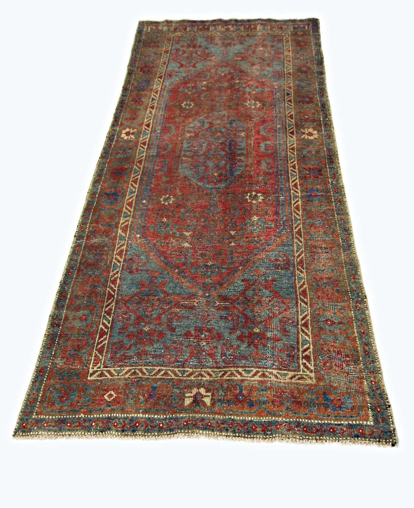 A vintage handmade Persian rug featuring a traditional geometric pattern in red and blue tones.