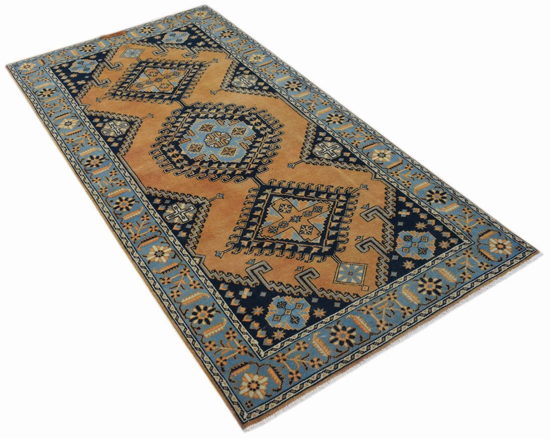 A rectangular vintage Persian rug featuring geometric medallions in blue and orange tones.
