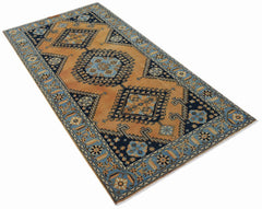 A rectangular vintage Persian rug featuring geometric medallions in blue and orange tones.