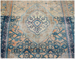 A vintage handwoven Persian rug featuring a central geometric medallion in blue, orange, and tan.