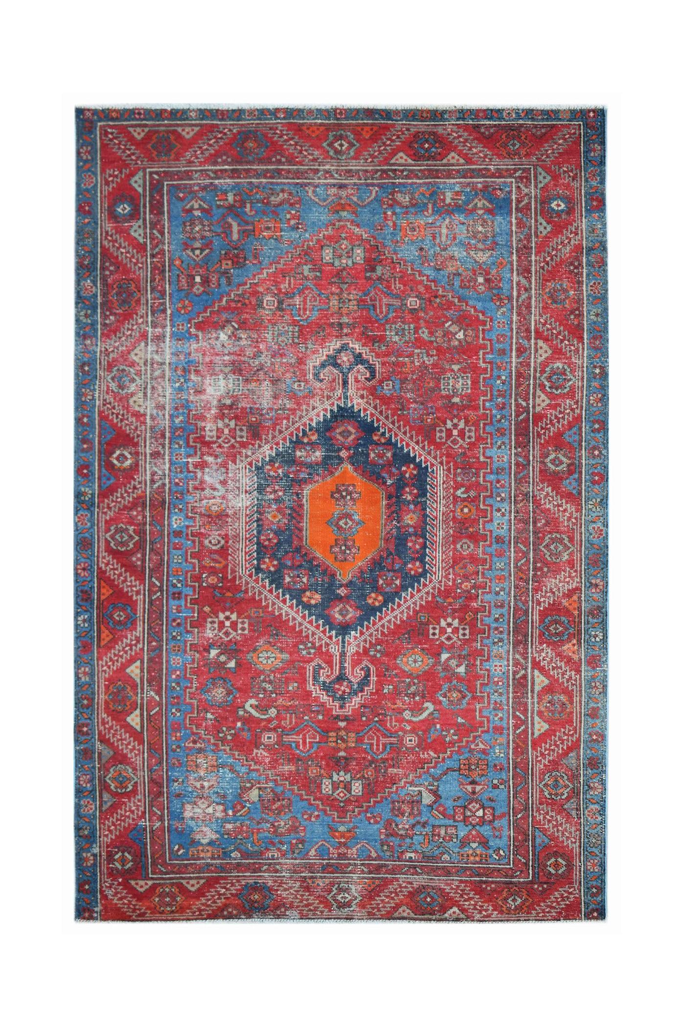 Vintage Persian rug featuring a central orange medallion on a red and blue geometric field.