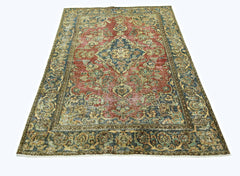 A vintage Persian rug featuring a central medallion and intricate floral patterns in red and blue.