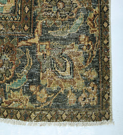 A vintage handmade Persian rug featuring intricate floral patterns in muted green and tan tones.