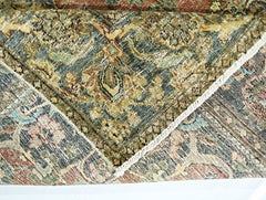 A folded vintage Persian rug featuring intricate floral patterns in muted earth tones.