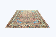 A vintage handmade Persian rug featuring a geometric floral pattern in pink and blue tones.