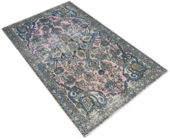 Vintage Persian rug with pink and blue floral patterns.
