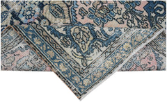 Vintage Persian rug with intricate blue, pink, and beige patterns.