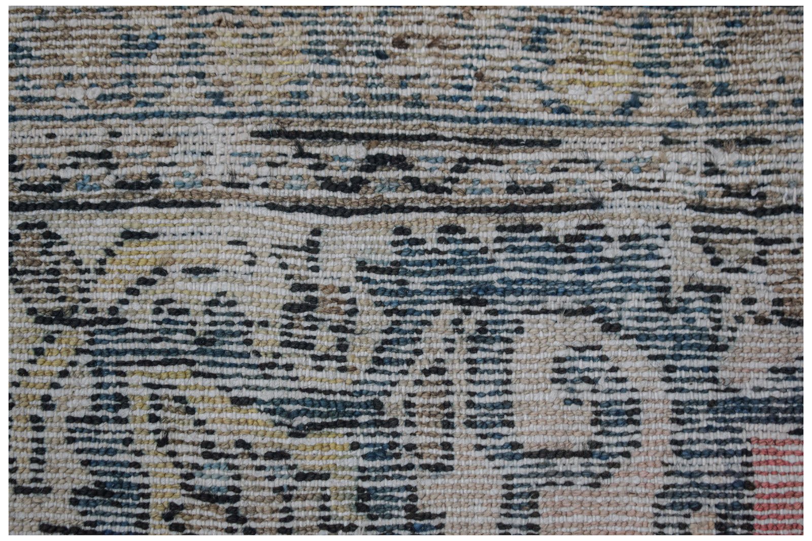 A close-up view of a handwoven vintage Persian rug featuring a distressed, multi-colored pattern.