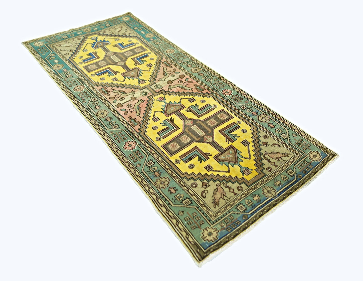 A vintage handmade Persian runner rug featuring geometric yellow medallions on a teal border.