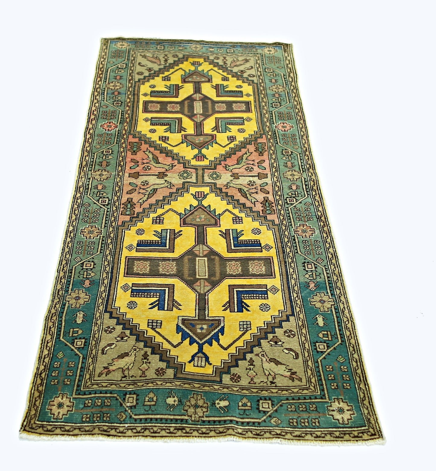 A handmade vintage Persian runner rug featuring geometric yellow medallions and teal borders.