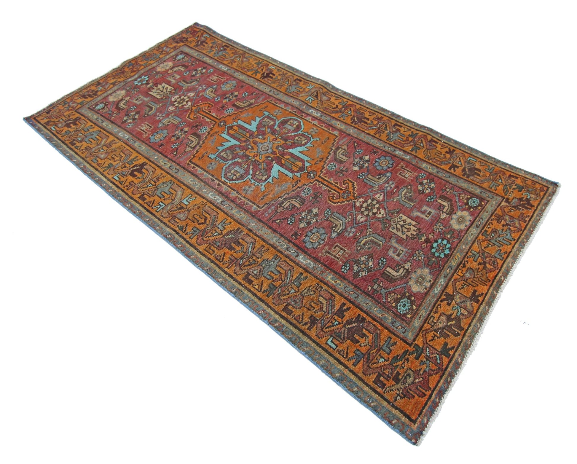A rectangular vintage Persian rug featuring a central floral medallion on a red field.