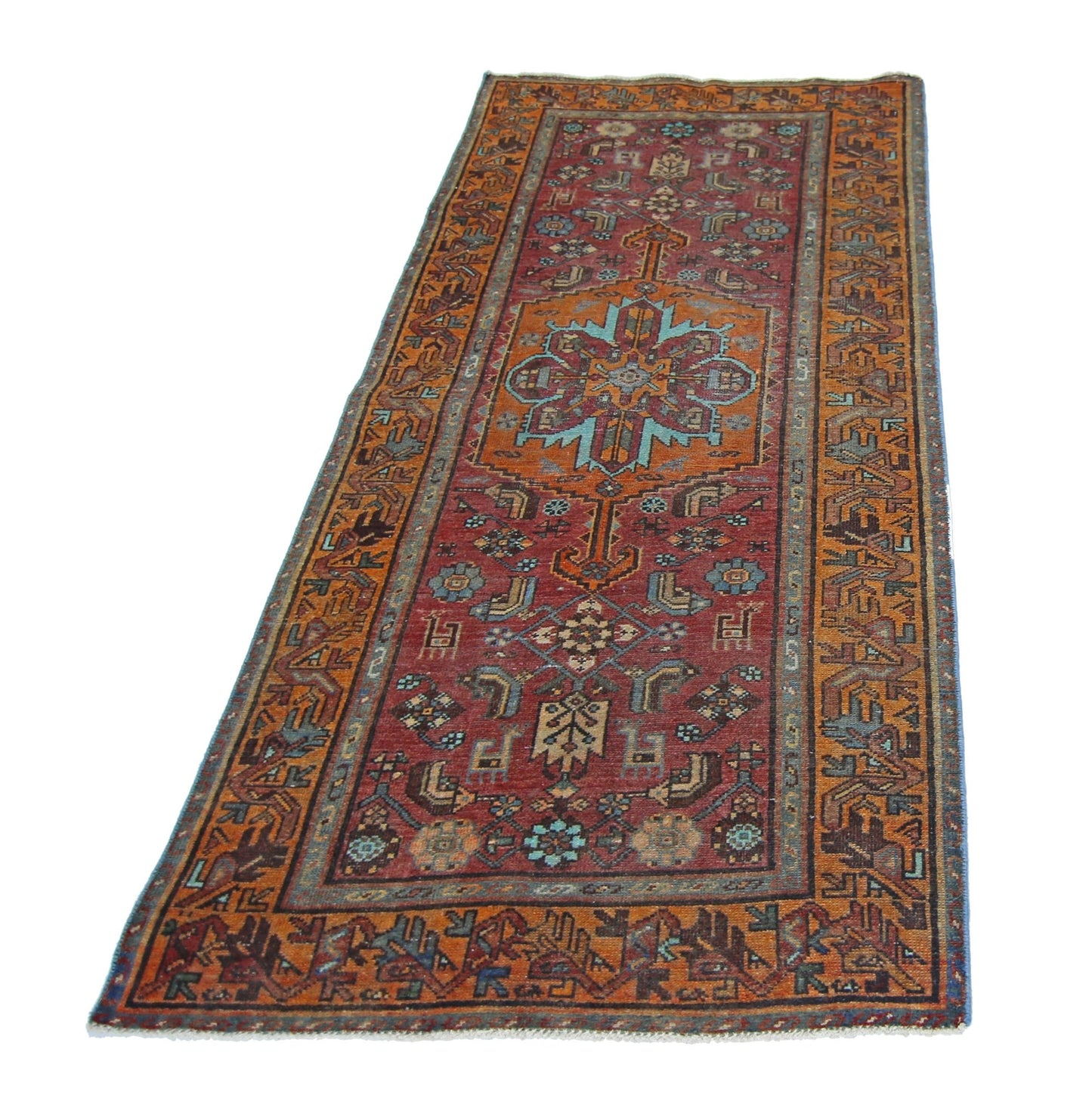 A vintage handmade Persian runner rug featuring a geometric floral pattern in red and orange tones.