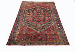 A vintage Persian rug featuring a central geometric medallion on a red field with blue borders.