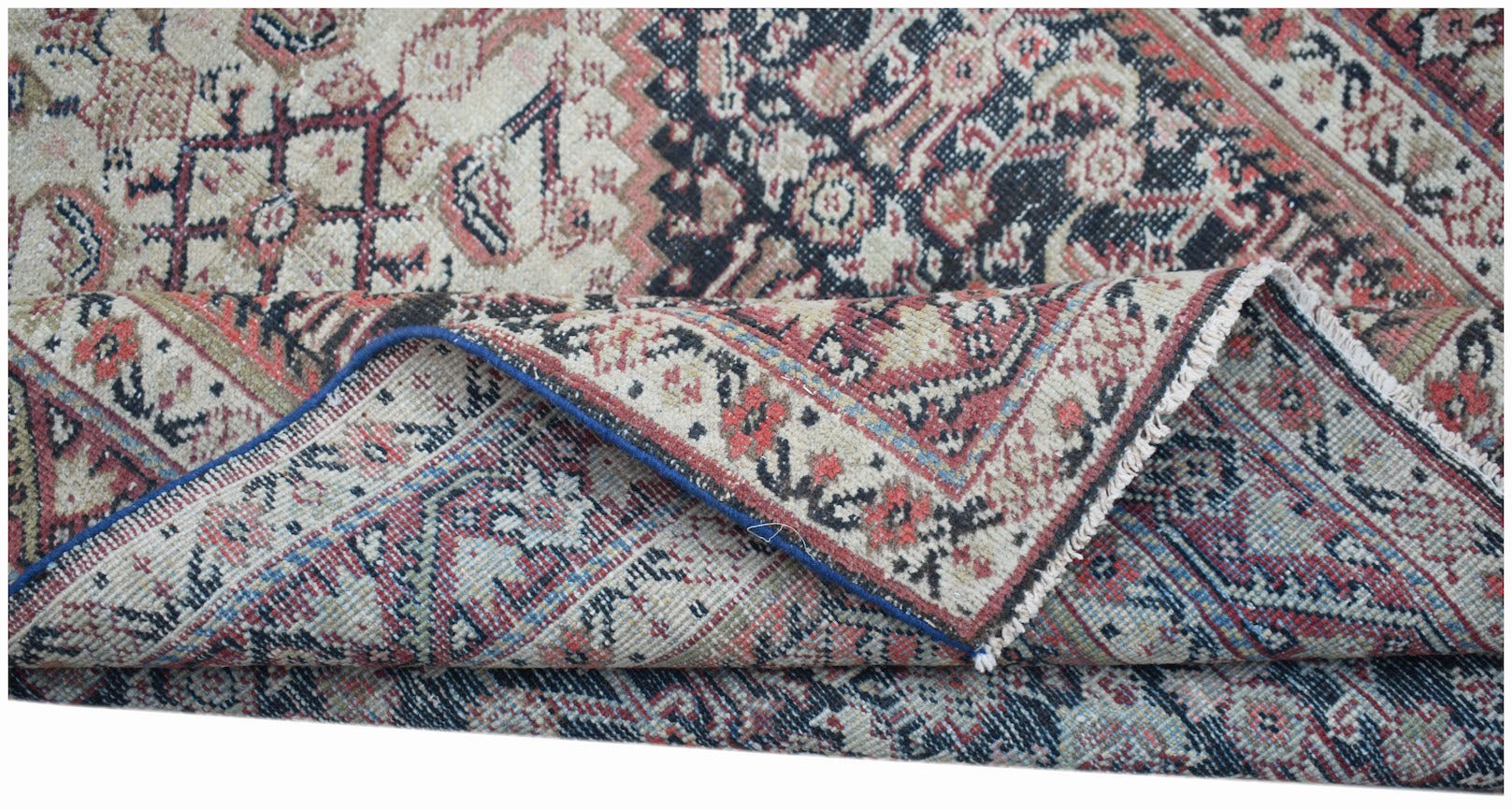 A handwoven vintage Persian rug featuring intricate floral patterns in red, blue, and cream.