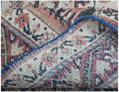 A folded corner of a vintage handwoven Persian rug featuring a traditional floral pattern.