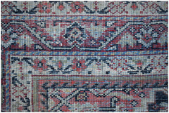 A close-up of a vintage handwoven Persian rug featuring intricate geometric and floral patterns.