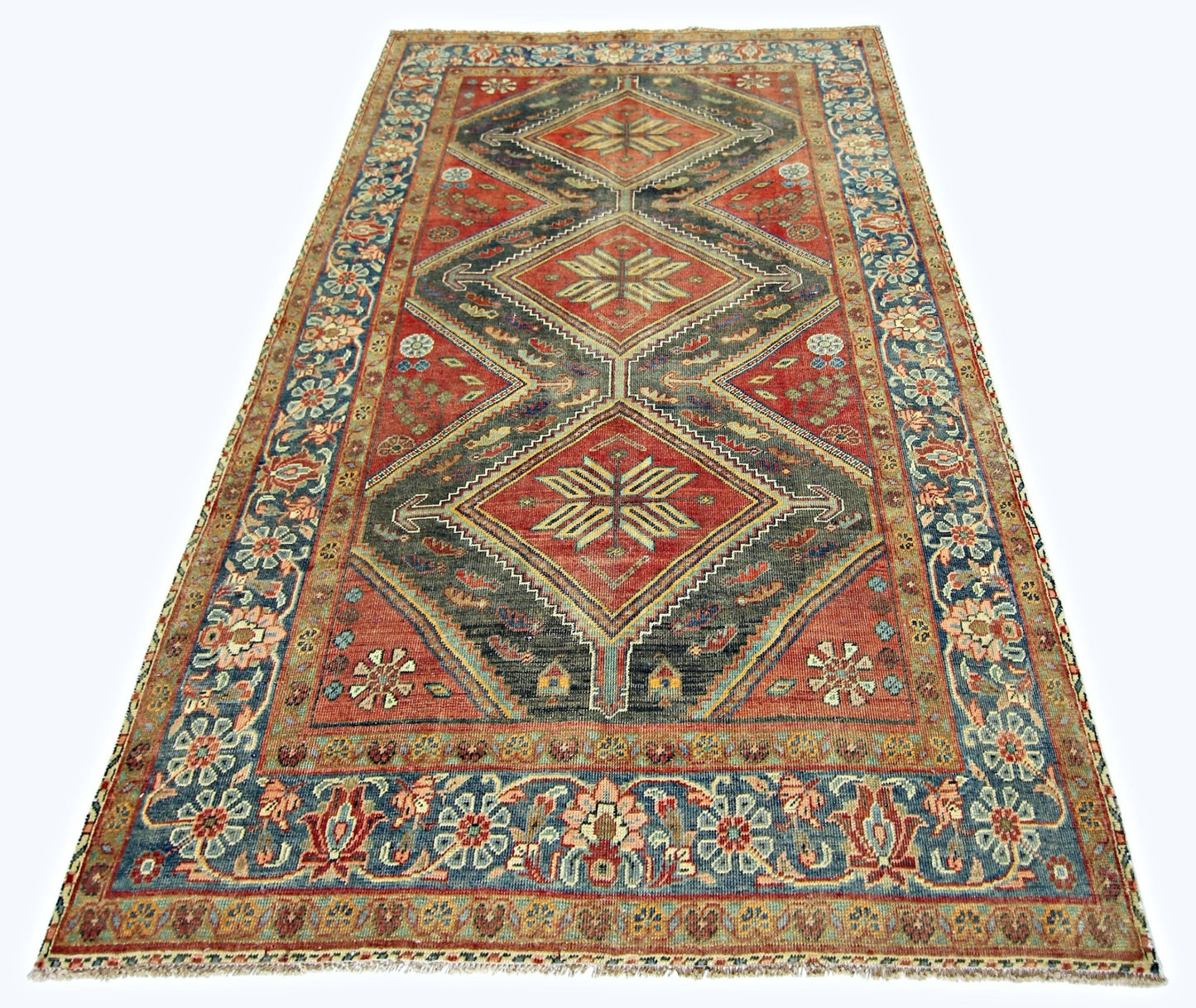 A vintage handmade Persian rug featuring three large diamond medallions on a red and grey field.