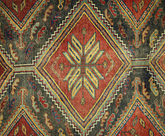 A vintage Persian rug featuring a geometric diamond pattern in red, blue, and yellow wool.