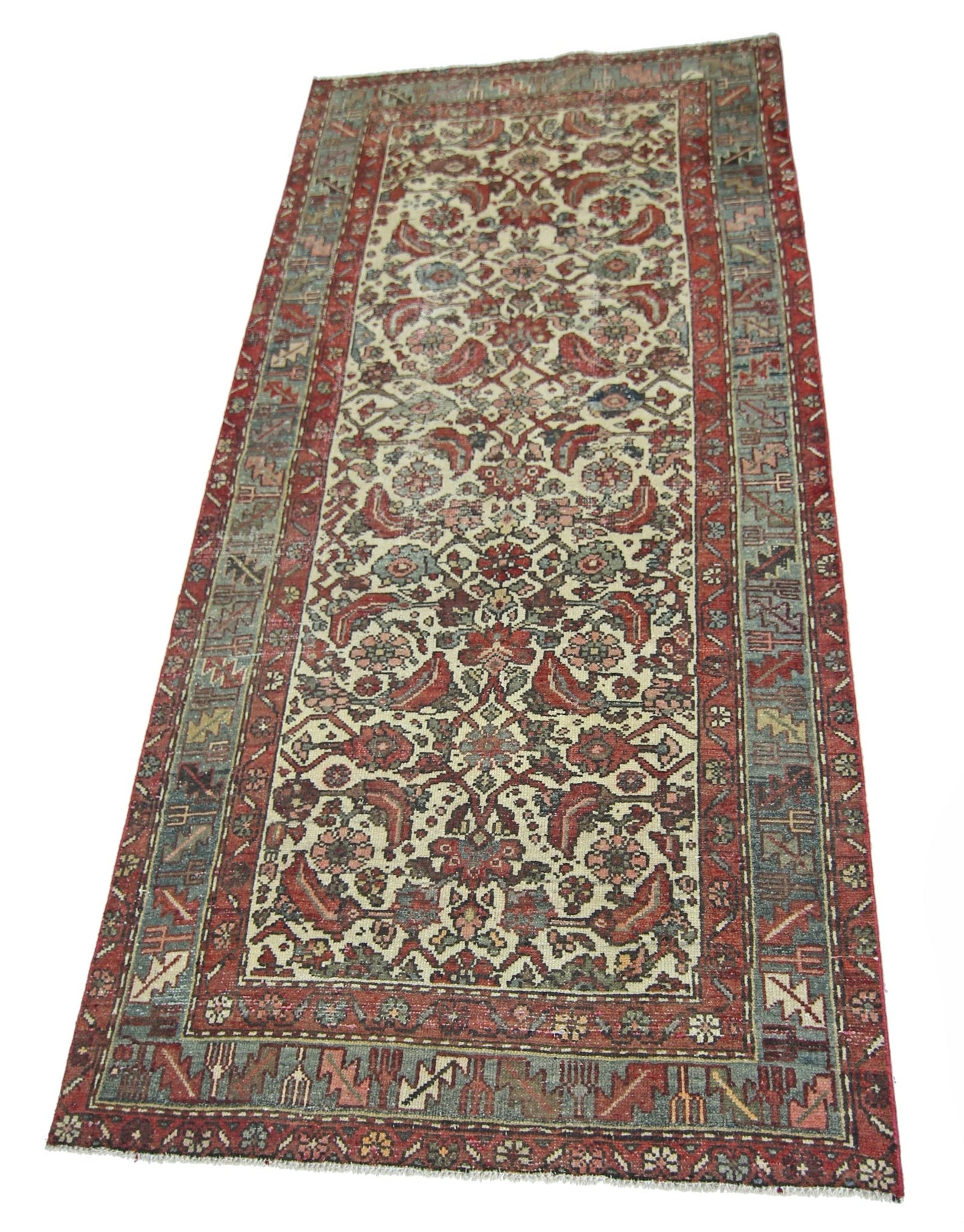 A vintage handmade Persian runner rug featuring a floral pattern in red, blue, and cream tones.
