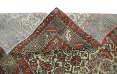 A vintage Persian rug with a folded corner showing its intricate floral pattern and wool construction.