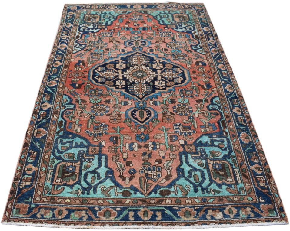 A vintage Persian wool rug featuring a central medallion on a salmon field with blue accents.