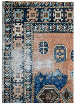 A vintage handwoven Persian rug featuring geometric patterns in orange, blue, and cream tones.