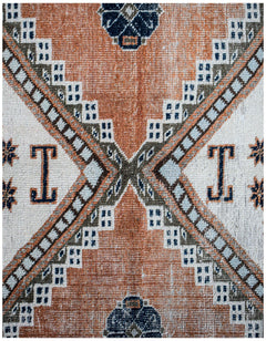 A vintage handwoven Persian rug featuring a geometric pattern in orange, white, and dark blue.