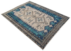 A vintage handwoven Persian rug featuring a geometric pattern in blue and beige tones.
