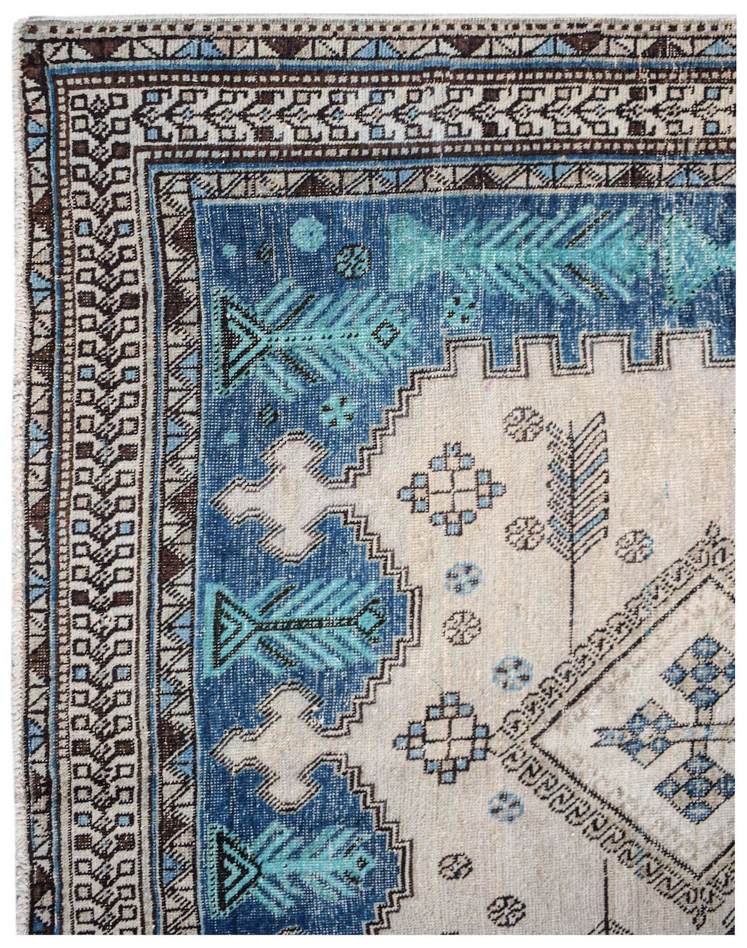 A vintage handwoven Persian rug featuring geometric blue and cream patterns.