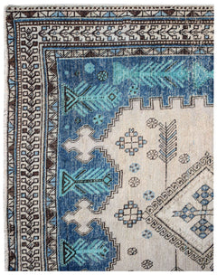 A vintage handwoven Persian rug featuring geometric blue and cream patterns.