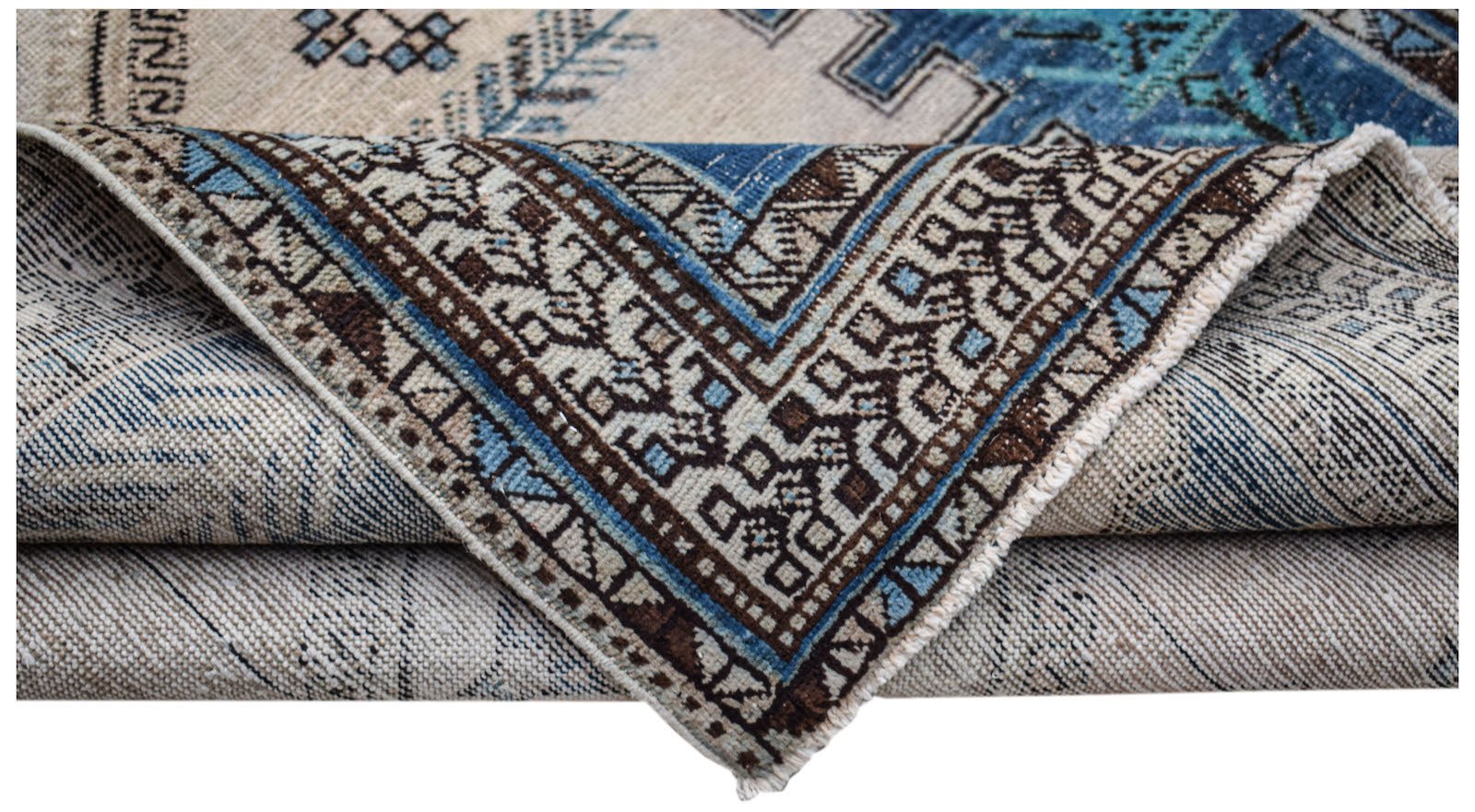 A handwoven vintage Persian rug featuring a geometric pattern in blue, brown, and cream tones.