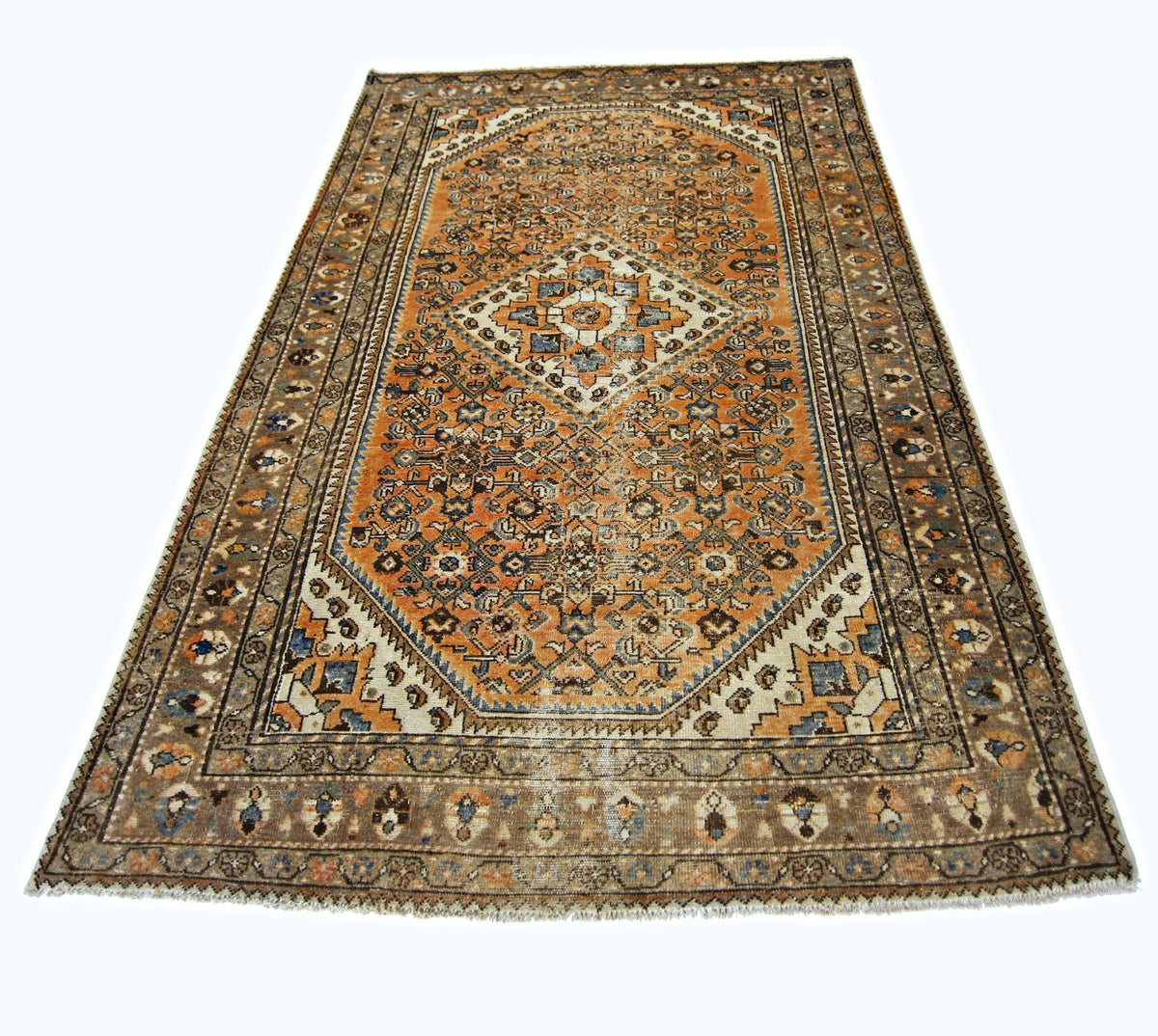 A vintage handmade Persian rug featuring an intricate orange and blue geometric pattern.