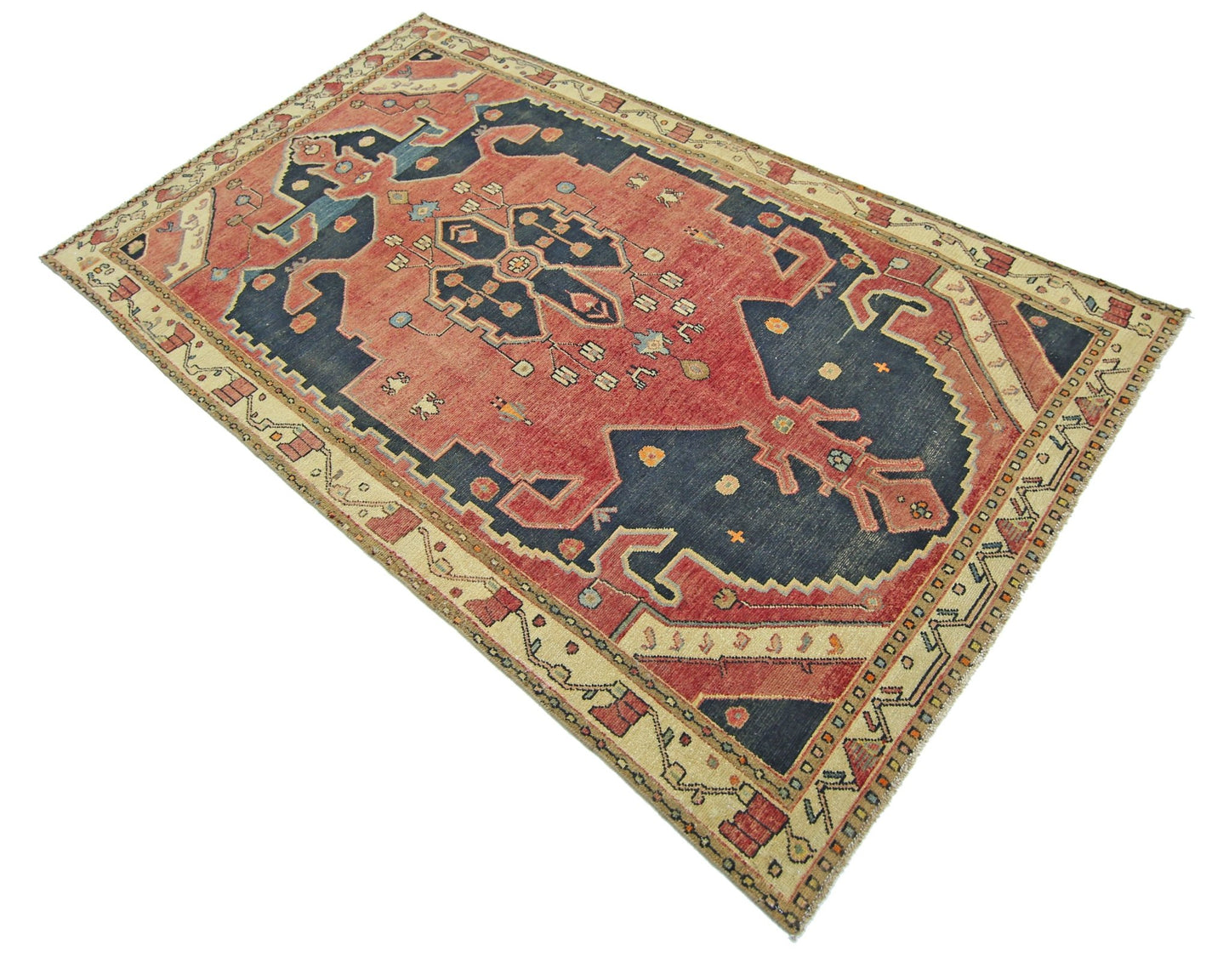 A vintage Persian rug featuring a dark blue central medallion on a red field with geometric borders.
