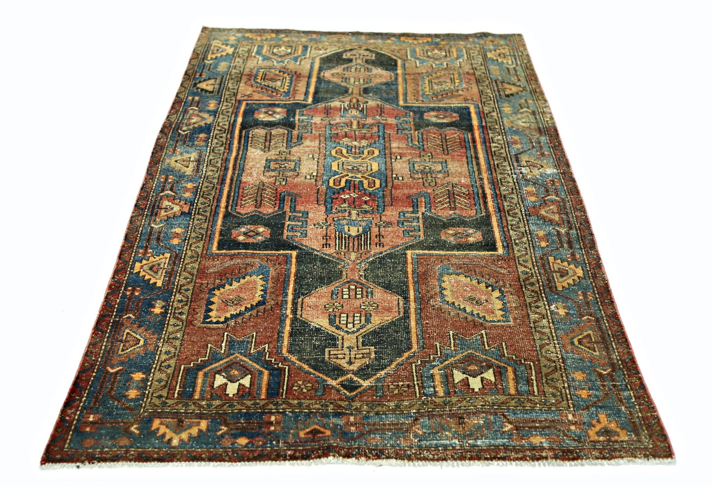 A vintage handmade Persian rug featuring a geometric pattern in shades of blue, red, and tan.