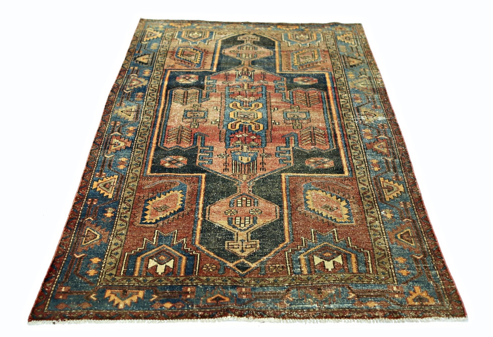 A vintage handmade Persian rug featuring a geometric pattern in shades of blue, red, and tan.