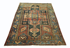 A vintage handmade Persian rug featuring a geometric pattern in shades of blue, red, and tan.