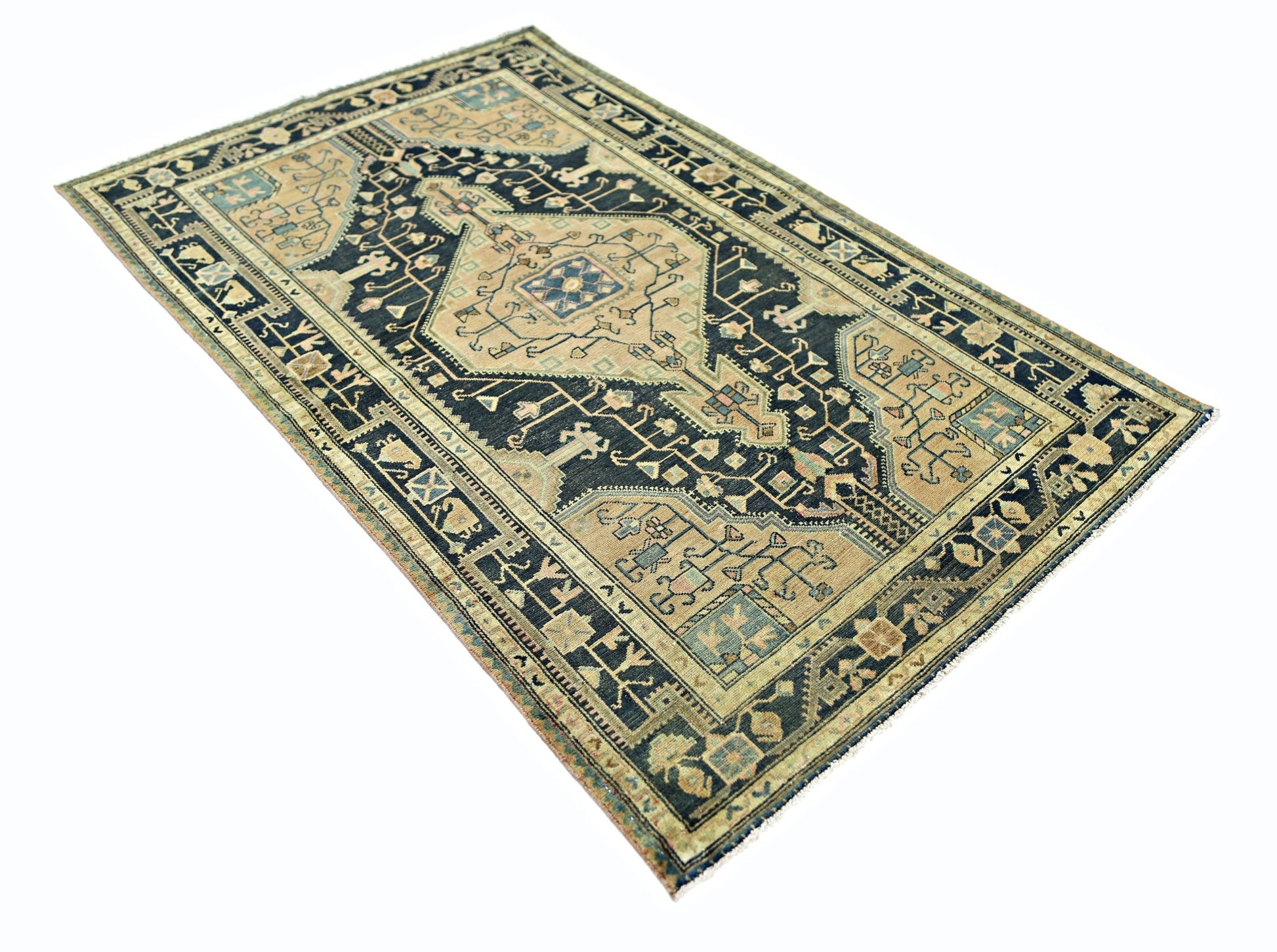A vintage handmade Persian rug featuring a central medallion on a dark blue and tan patterned field.