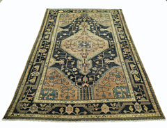 A vintage Persian rug featuring a geometric diamond medallion pattern in blue and tan tones.