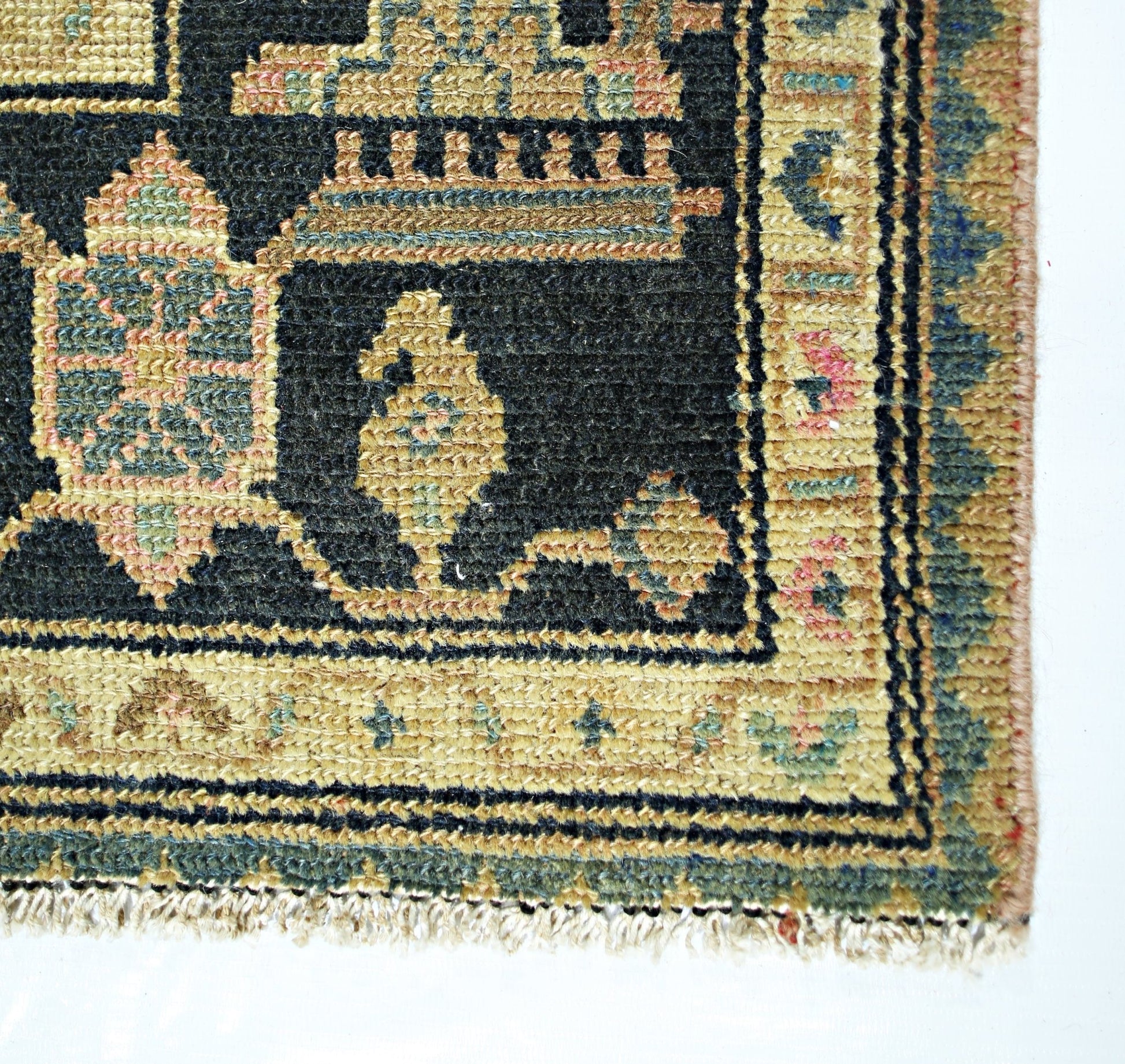 A vintage Persian rug featuring a black field with intricate geometric patterns and a tan border.