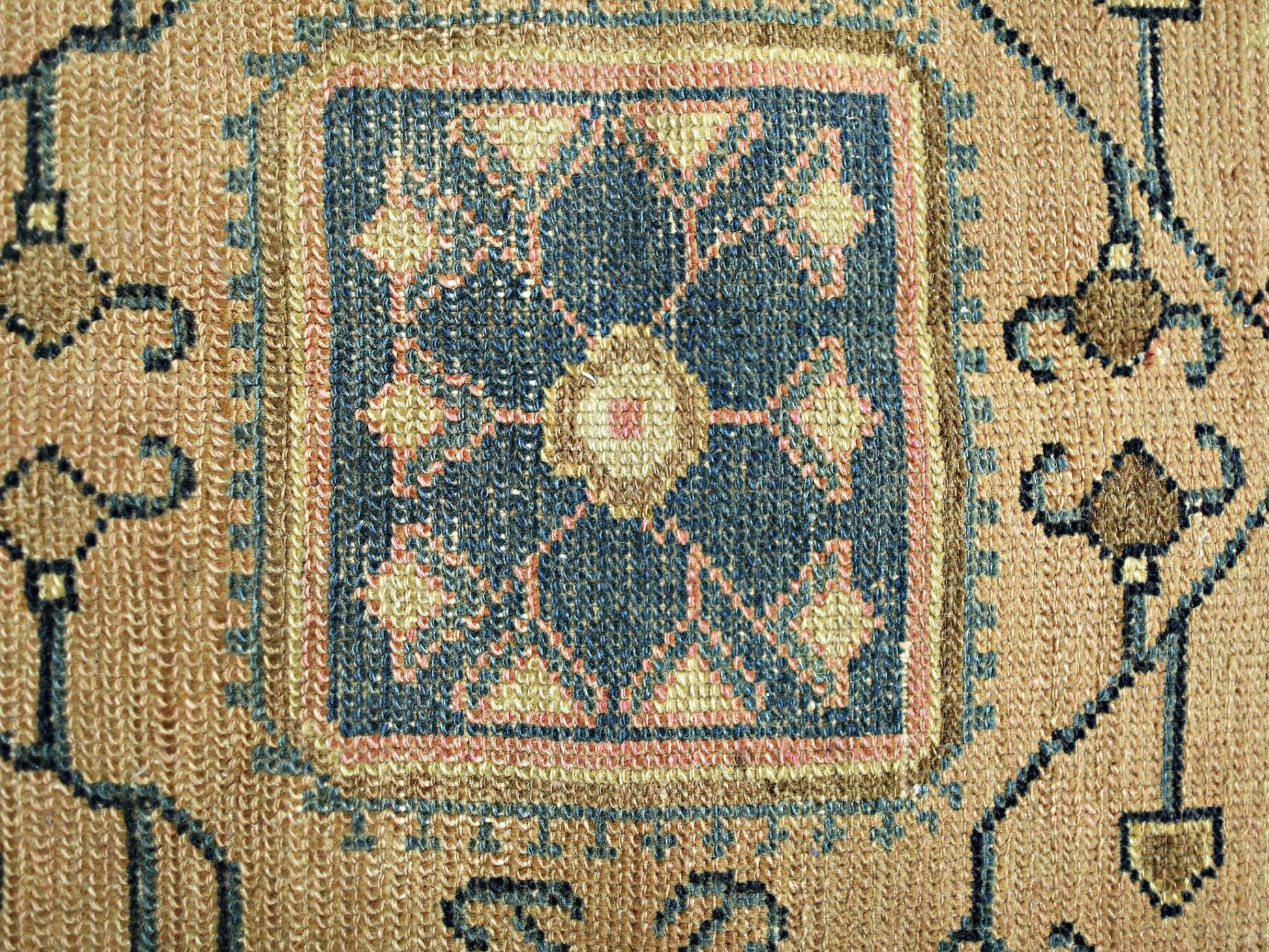 A vintage Persian rug featuring a central blue geometric medallion with intricate floral patterns.