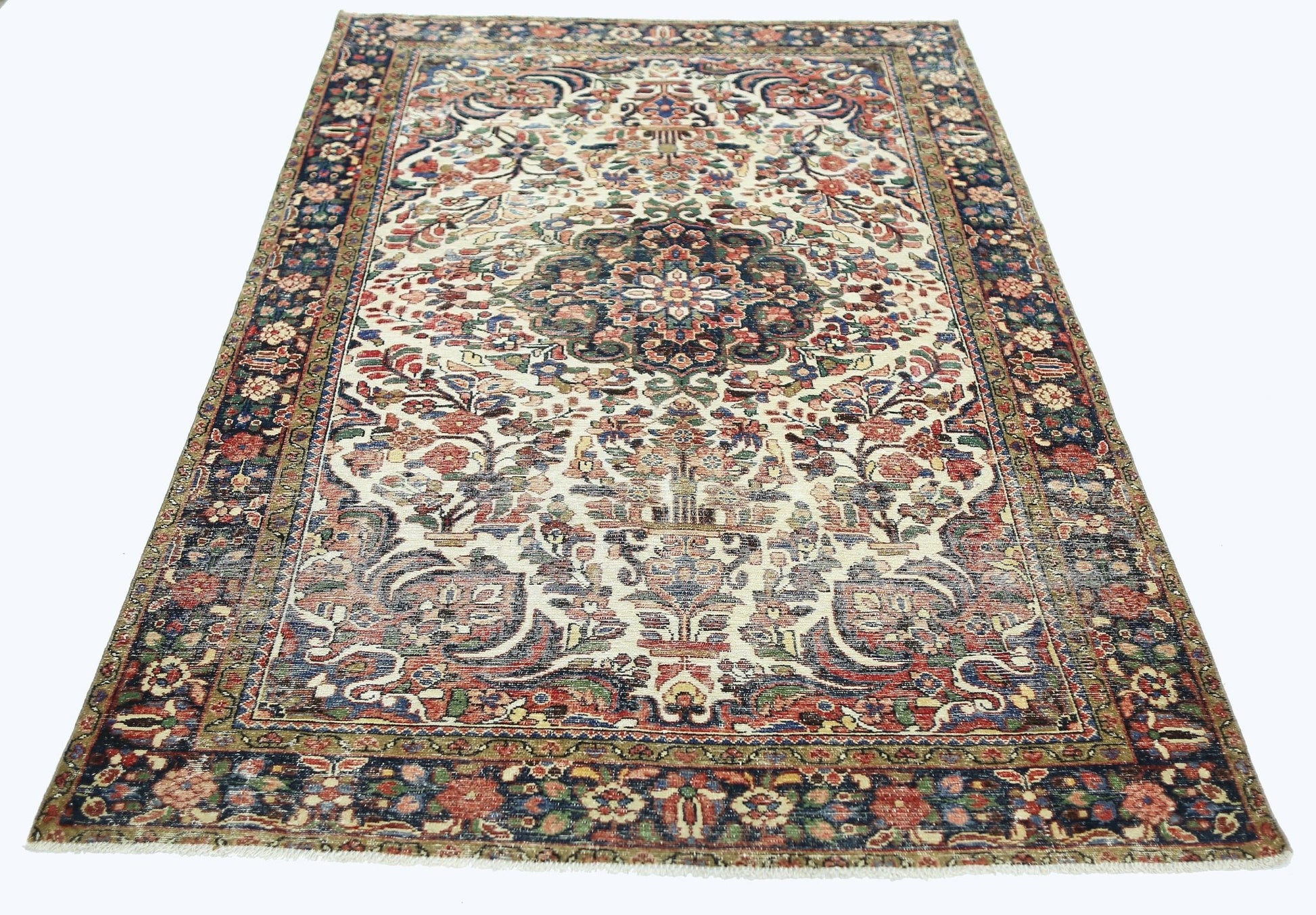 A vintage Persian rug featuring a central floral medallion on a cream field with a dark border.