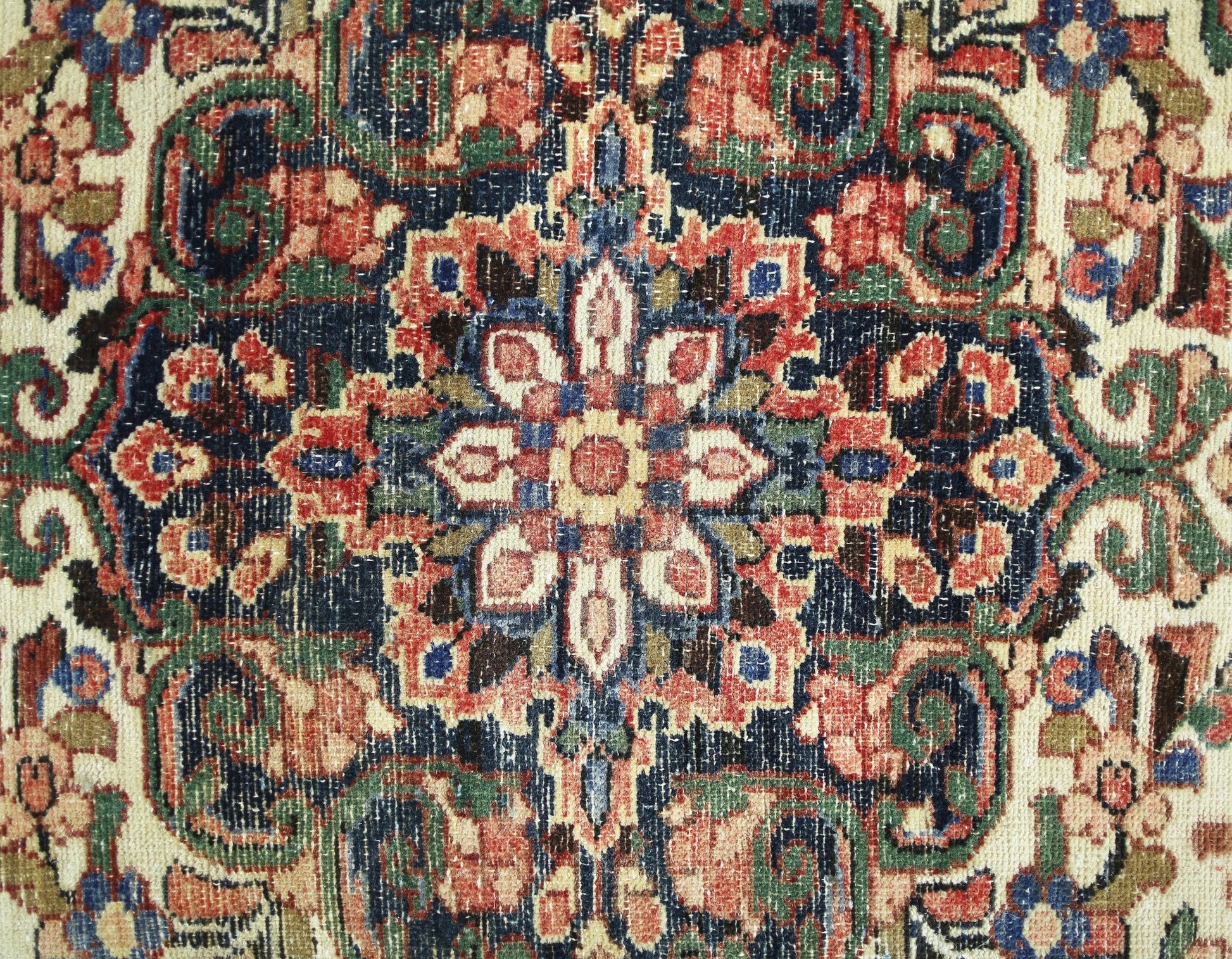 A vintage Persian rug featuring a detailed floral medallion pattern in red, blue, and green tones.
