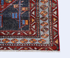 A corner view of a vintage Persian rug featuring geometric patterns in red, blue, and gold.