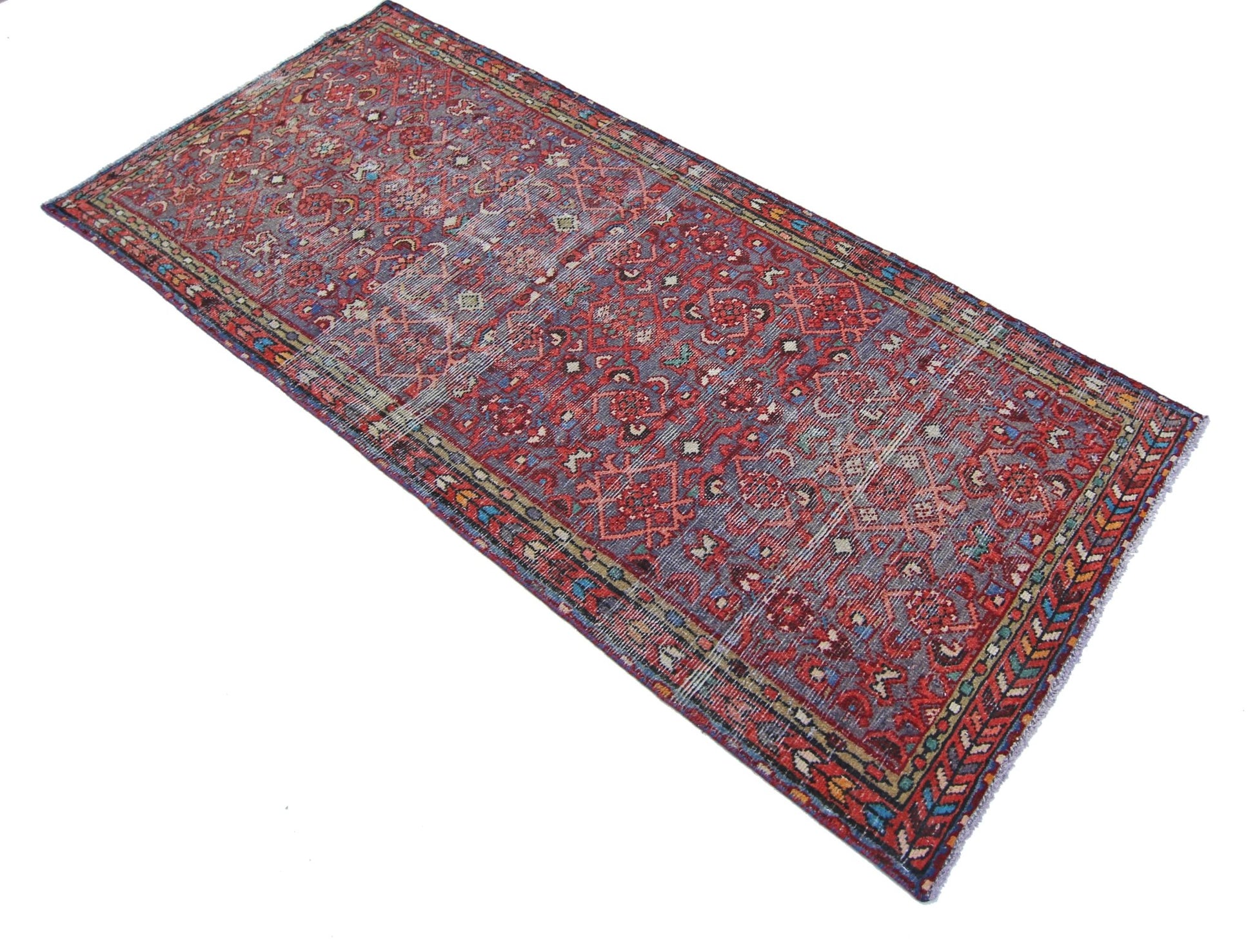 A rectangular vintage Persian rug featuring intricate floral patterns in red and blue tones.