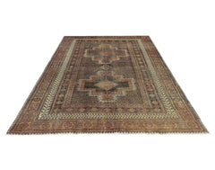 A vintage Persian rug featuring a dark brown field with two central geometric medallions.