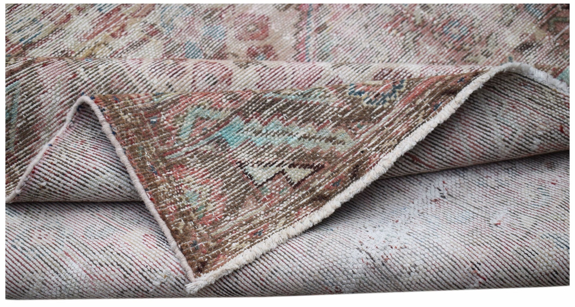 A vintage handwoven Persian rug featuring a faded floral pattern in muted red, blue, and brown.