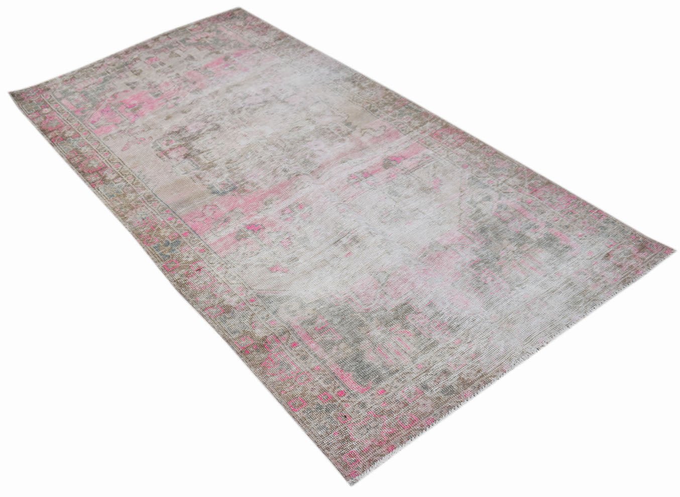 A vintage handwoven Persian rug featuring a distressed pattern in shades of pink and grey.