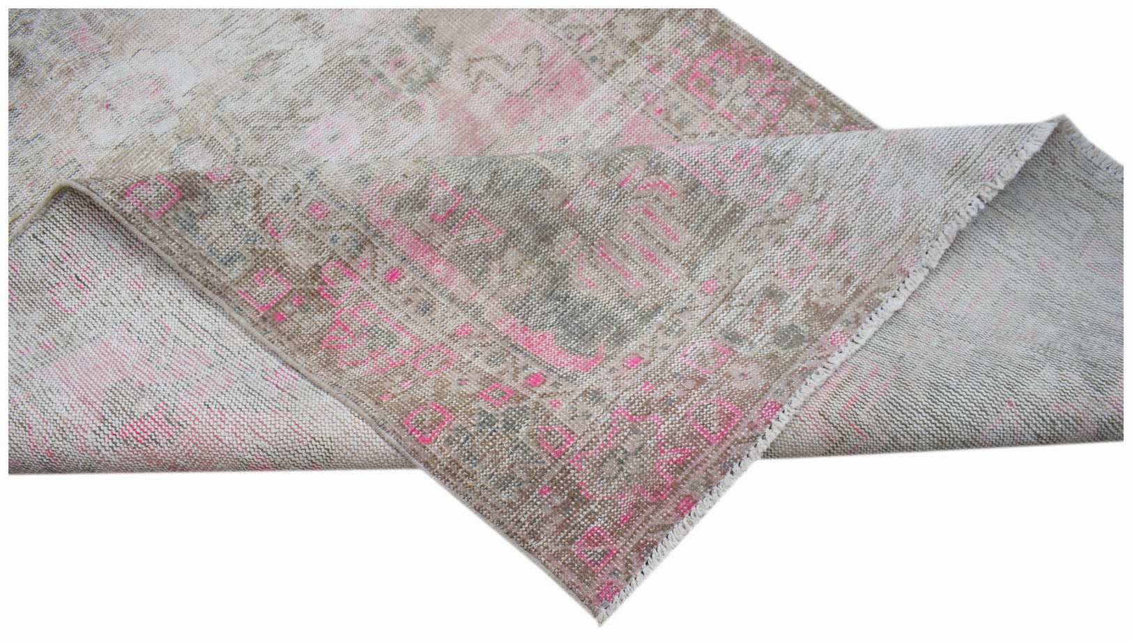 A vintage handwoven Persian rug featuring a faded beige and pink geometric pattern.