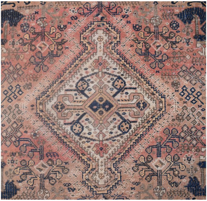 A vintage handmade Persian wool rug featuring a central diamond medallion in muted earth tones.