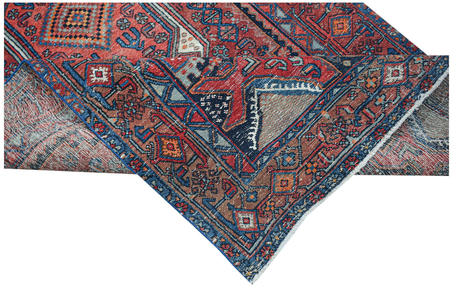 A handwoven vintage Persian rug featuring intricate geometric patterns in red, blue, and brown.